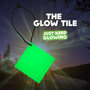 Bright green Glow Tile square hanging from its reflective paracord loop, demonstrating its reusable glow-in-the-dark capability for emergencies and camping.
