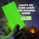 Emergency Glow Bar by Just Keep Glowing. 'Lights On, Even When The Powers Gone!'  Bright green glow bar held in hand against starry night sky.  Reliable light source for power outages and outdoor adventures.  Essential for camping, hiking, and emergency kits.  Long-lasting glow, no batteries needed.