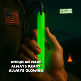 Close-up of a person holding the reusable glow stick with an American flag patch visible on their backpack.
