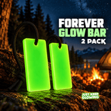 Two reusable green Forever Glow Bars with black paracord displayed on a rock at a mountain campsite with a campfire and tent.