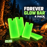 Four green Forever Glow Bars with black paracord arranged at a nighttime mountain campsite, showing the four pack for camping and emergency gear.