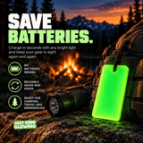 Forever Glow Bar glowing green on a camping backpack beside a flashlight, showing reusable battery free glow gear for locating equipment after dark.