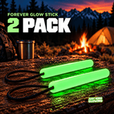 Two green reusable Forever Glow Sticks with black paracord loops displayed on a wooden camping table near a campfire and tent.