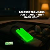 Glow bar packed in suitcase next to passport and headphones – travel pack light emergency kit.