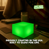 Glow Cube XL glowing on a workbench with American flag, handmade in the USA premium glow light built to last.