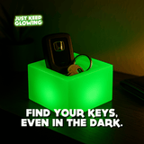 Glow Cube XL used as a glowing tray holding car keys, glow-in-the-dark night stand organizer and storage light.
