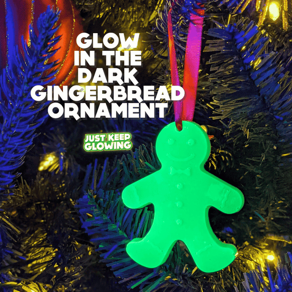 Bright green glow-in-the-dark gingerbread man ornament hanging on a Christmas tree, perfect for unique holiday decor and sustainable glow.