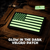 Glow-in-the-dark American flag morale patch with Velcro backing mounted on a tactical backpack, glowing in low-light conditions.