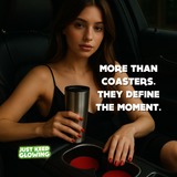 Woman holding a metallic cup with text 'More than coasters. They define the moment.' and 'Just Keep Glowing' logo.