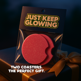 Gift-ready set of 2 glittery pink glow in the dark car coasters in Just Keep Glowing packaging with gold ribbon, perfect handmade car accessory gift for women and men.