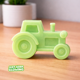 Glow-in-the-dark tractor toy shown in daylight, handmade in the USA, smooth resin tractor design for kids and gifts