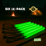 Six (6) pack of reusable green glow sticks with paracord loops on a wooden table near a tent. Best Price.