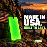 American made Forever Glow Bar glowing green on a rugged outdoor backpack with an American flag patch and mountain sunset.