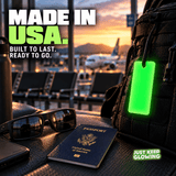 Green Forever Glow Bar attached to a travel backpack in an airport terminal, highlighting American manufacturing and durable reusable glow gear for frequent travelers.
