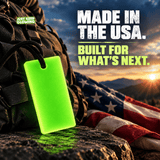 Forever Glow Bar glowing green beside a survival backpack and American flag at sunset, highlighting American-made reusable glow gear for emergency preparedness and outdoor equipment.