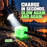 Bright flashlight charging a green Mini Glow Cube on a rock at sunset, showing how the reusable glow in the dark marker charges with light.