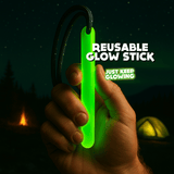 Reusable glow stick held in a hand, showing the cord loop. American Made. Just Keep Glowing.
